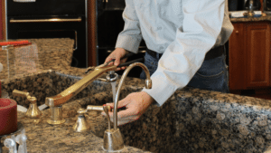 Family-owned Befort plumber repairing a kitchen sink drain in an Englewood, CO home.