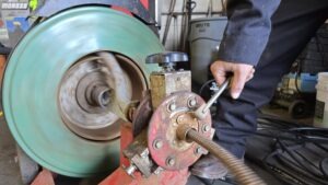 Professional plumber using a high-powered rooter machine to clear a clogged main sewer line for a Denver homeowner.