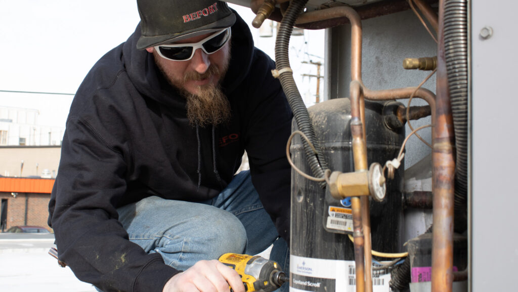 HVAC Technician working on a roof RTU unit in Denver